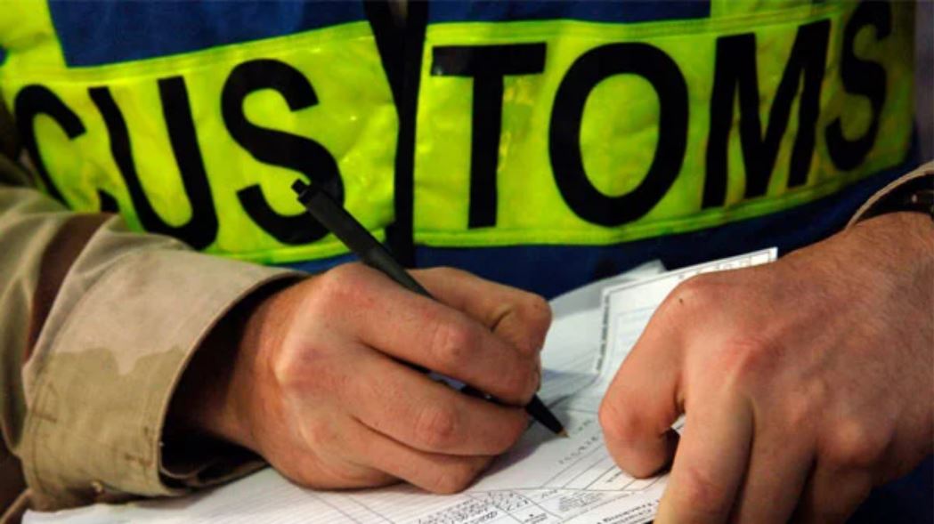 Customs officer inspecting paperwork during a parcel inspection related to cannabis seeds